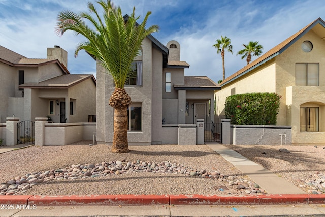 view of front of property with fence private yard, a gate, and stucco siding