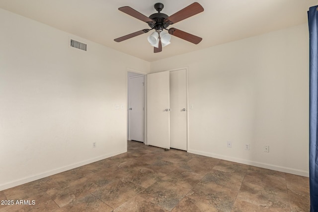 unfurnished bedroom with baseboards, stone finish flooring, and visible vents