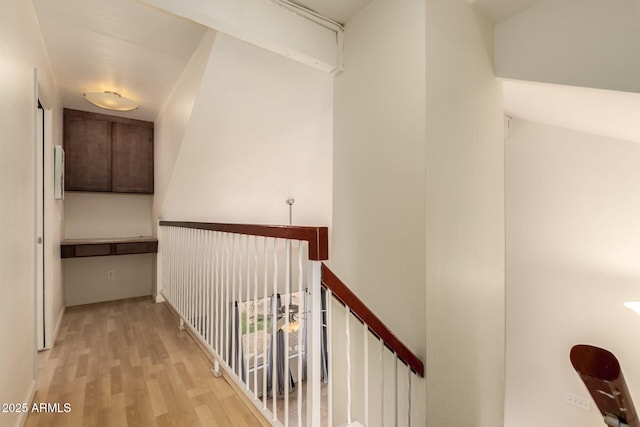 hallway featuring wood finished floors and an upstairs landing