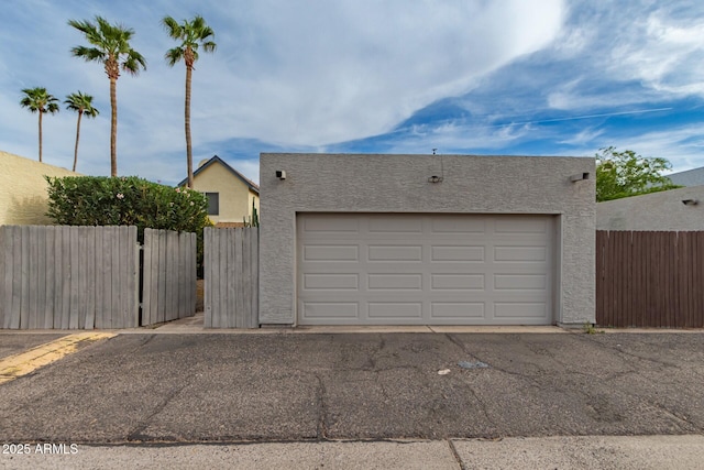garage featuring fence and driveway