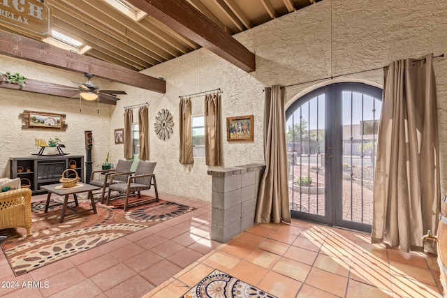 entrance foyer with french doors, lofted ceiling with beams, tile patterned floors, and ceiling fan