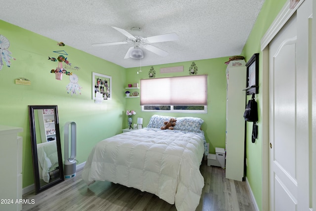 bedroom featuring wood-type flooring, ceiling fan, a closet, and a textured ceiling