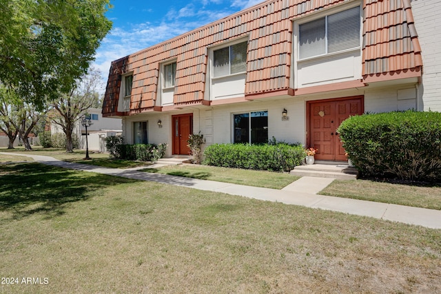 view of property featuring a front lawn