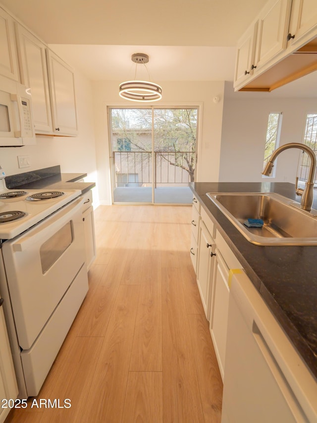 kitchen featuring pendant lighting, sink, white appliances, white cabinets, and light wood-type flooring