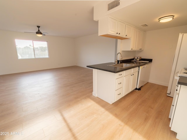 kitchen featuring white cabinetry, sink, white dishwasher, and kitchen peninsula