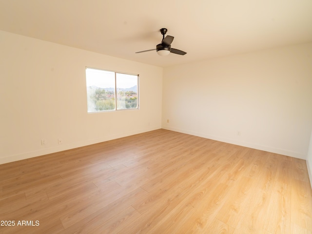 spare room with ceiling fan and light wood-type flooring