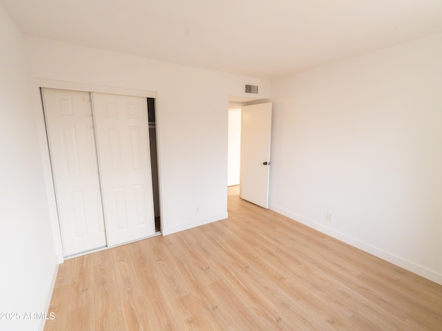 unfurnished bedroom with light hardwood / wood-style floors and a closet