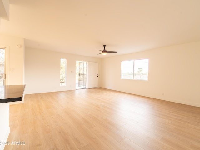 unfurnished living room featuring ceiling fan and light hardwood / wood-style floors