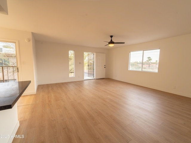 unfurnished living room with ceiling fan and light hardwood / wood-style floors