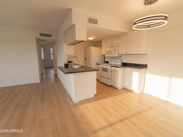 kitchen featuring sink, decorative light fixtures, light wood-type flooring, white appliances, and white cabinets