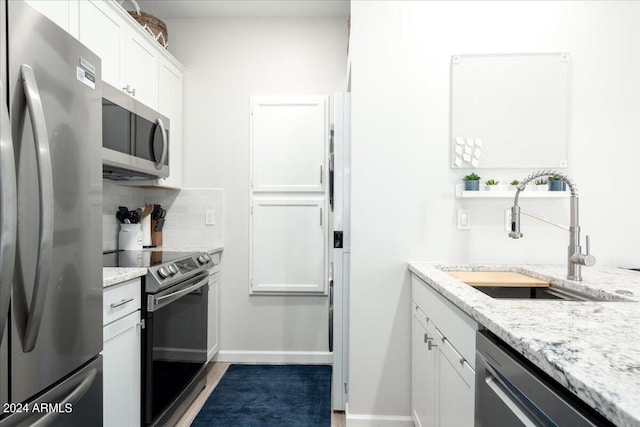 kitchen with dark hardwood / wood-style flooring, backsplash, sink, white cabinetry, and appliances with stainless steel finishes