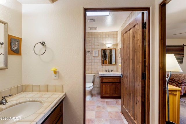 25002 N Quail Haven Dr, Rio Verde, AZ 85263 - bathroom featuring vanity, toilet, tile walls, and tile patterned floors
