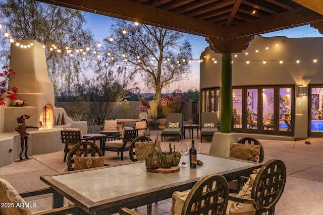 25002 N Quail Haven Dr, Rio Verde, AZ 85263 - patio terrace at dusk with exterior fireplace, a patio area, and outdoor dining space