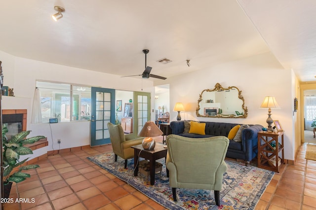 tiled living area featuring baseboards, ceiling fan, visible vents, and french doors