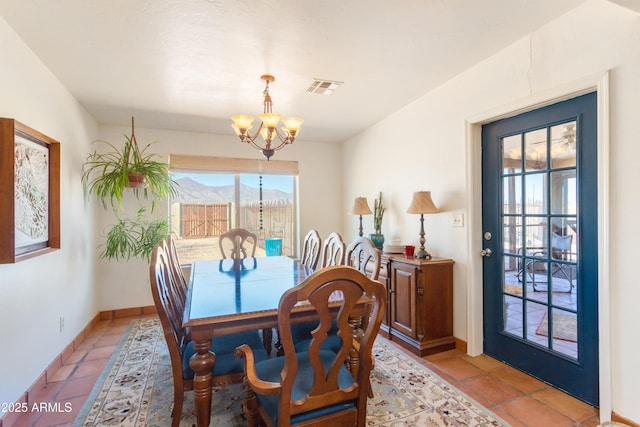 dining room featuring light tile patterned flooring, a chandelier, baseboards, visible vents, and a mountain view