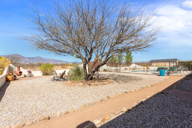 view of yard featuring a fenced in pool, a mountain view, fence, and a patio area