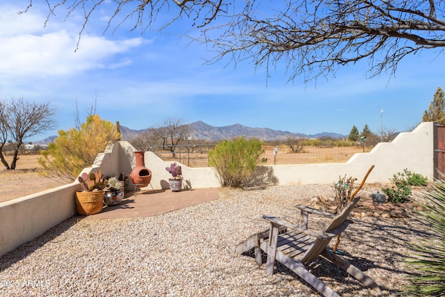 view of yard featuring fence, a patio, and a mountain view