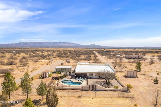 drone / aerial view featuring a mountain view, view of desert, and a rural view