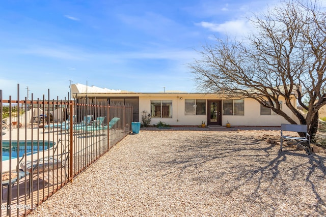 back of property featuring a patio, a fenced in pool, fence, and stucco siding