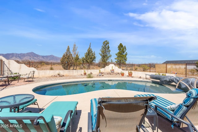 view of pool with a fenced backyard, a patio, a mountain view, and a fenced in pool