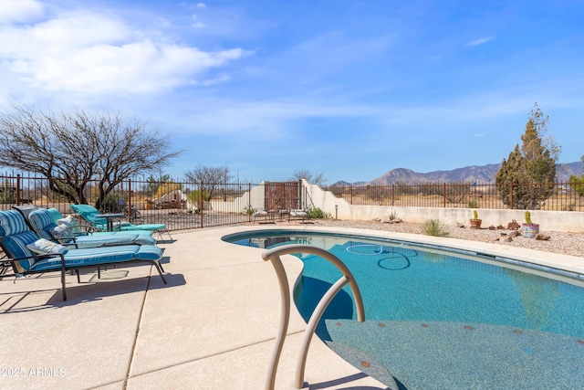 view of pool with a fenced backyard, a fenced in pool, a mountain view, and a patio