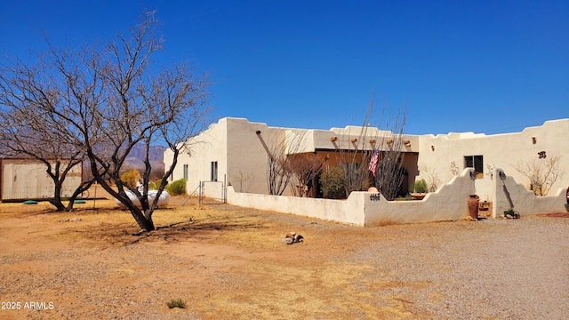 view of home's exterior with stucco siding and fence