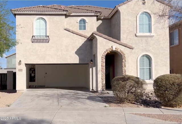 mediterranean / spanish-style house with driveway, a tile roof, and stucco siding