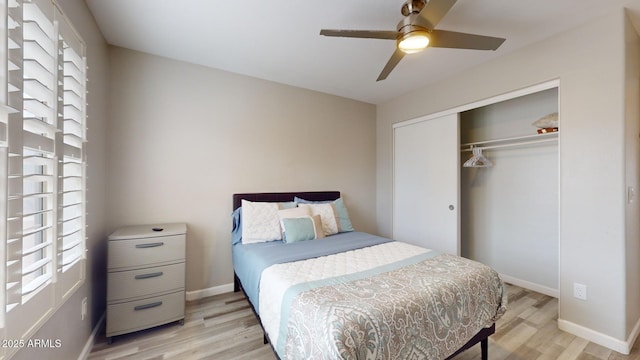 bedroom featuring multiple windows, light hardwood / wood-style floors, a closet, and ceiling fan