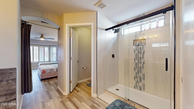 bathroom featuring wood-type flooring, a shower with door, and ceiling fan