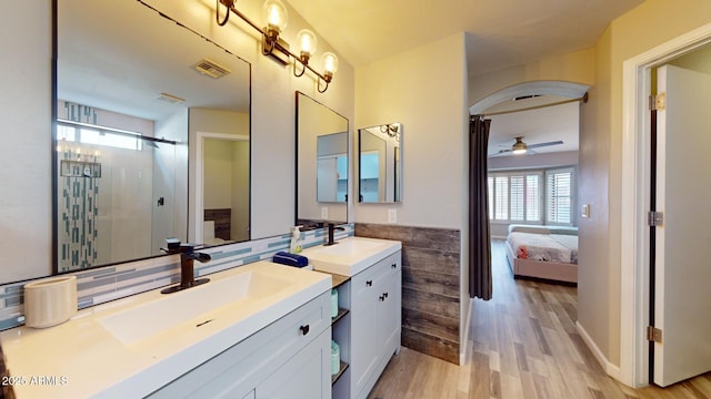 bathroom featuring walk in shower, hardwood / wood-style floors, vanity, and ceiling fan