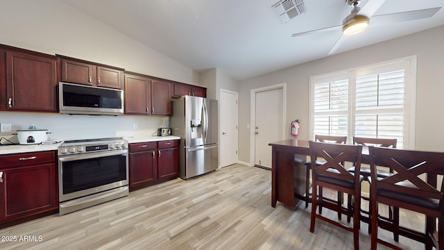 kitchen featuring light wood-type flooring, stainless steel appliances, vaulted ceiling, and ceiling fan