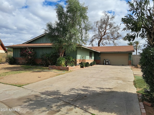 single story home with a garage, driveway, board and batten siding, and brick siding