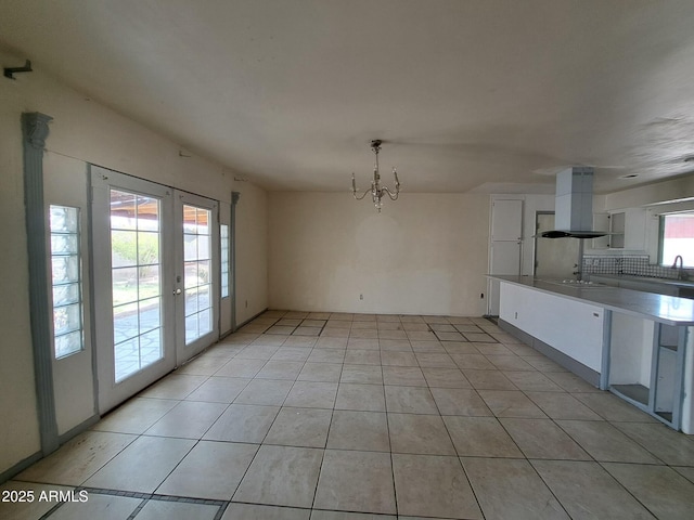 unfurnished dining area featuring light tile patterned floors and french doors