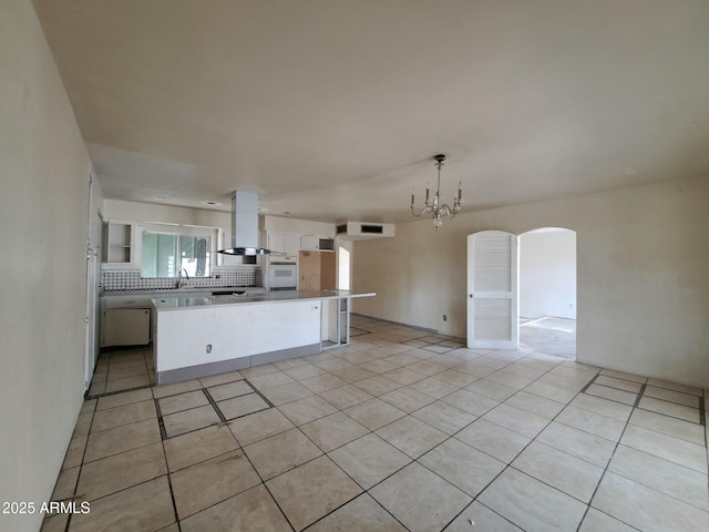 kitchen with white cabinetry, open floor plan, white oven, decorative backsplash, and island exhaust hood