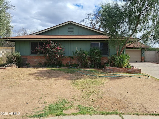 ranch-style home with board and batten siding, concrete driveway, brick siding, and a garage