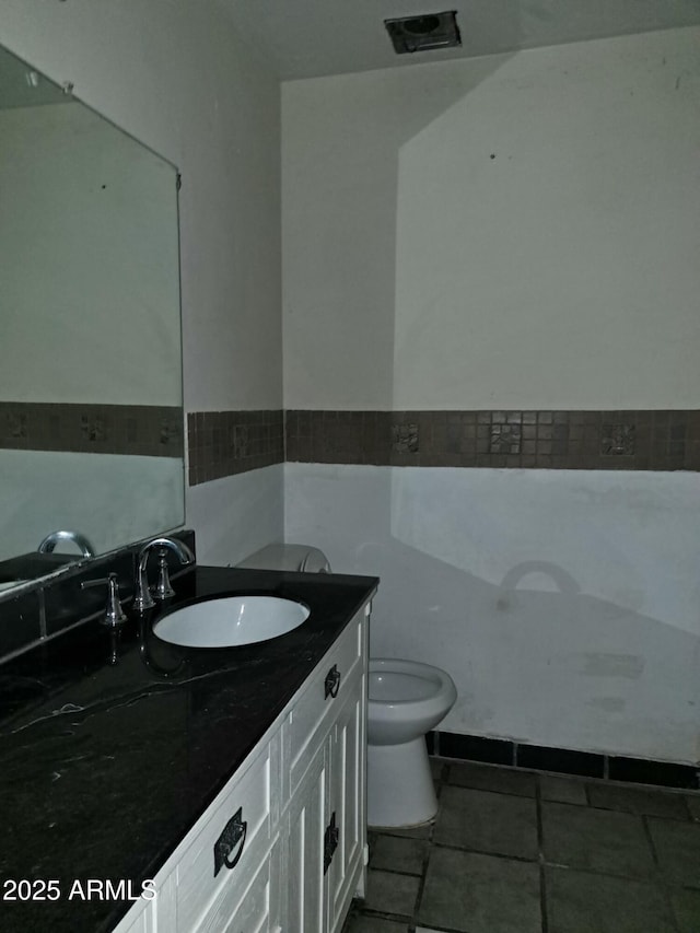 bathroom with toilet, tile patterned flooring, and vanity