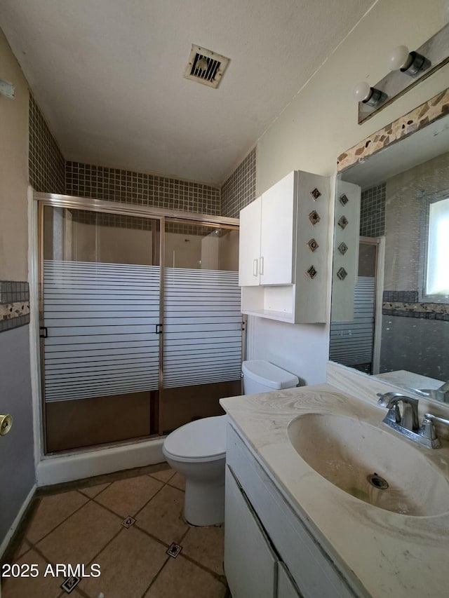 bathroom with visible vents, a shower stall, and tile patterned floors