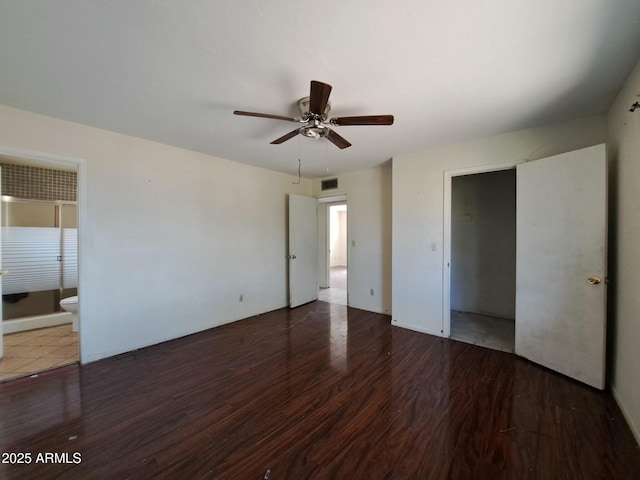 unfurnished bedroom featuring a ceiling fan, wood finished floors, visible vents, and connected bathroom