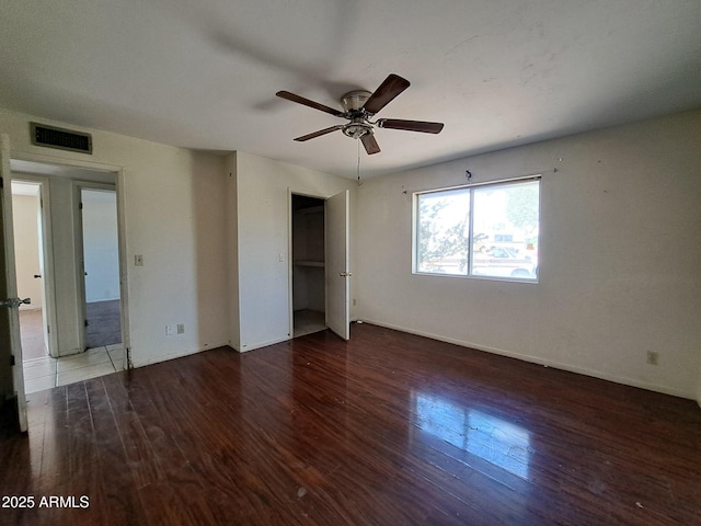 unfurnished bedroom with baseboards, visible vents, ceiling fan, and wood finished floors