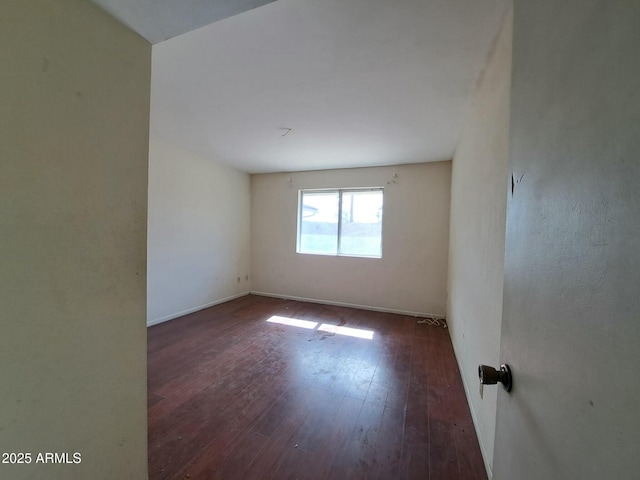 empty room featuring baseboards and wood finished floors