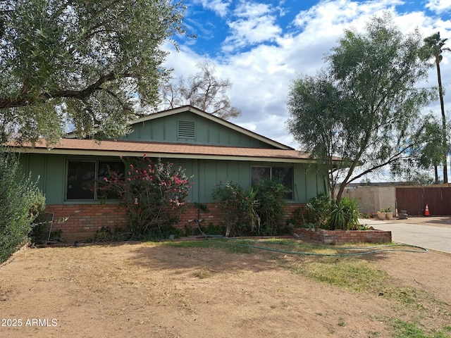 view of front of property featuring board and batten siding and brick siding