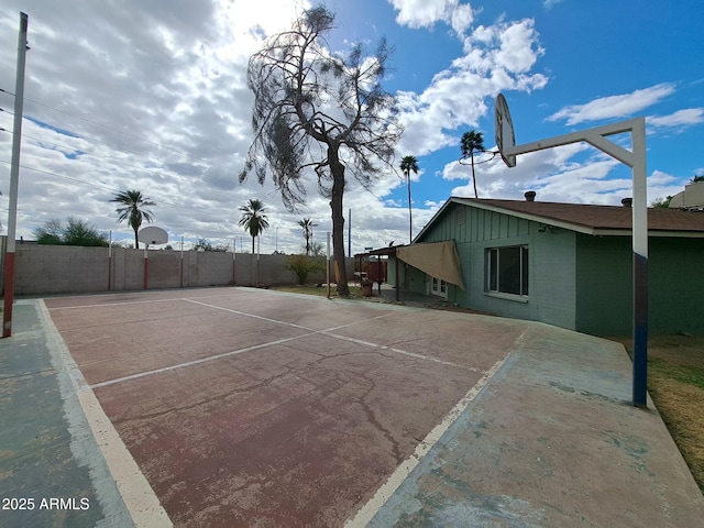 exterior space featuring fence and basketball hoop