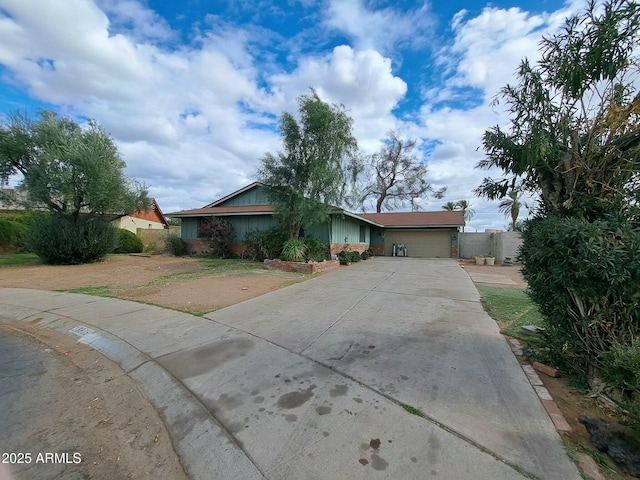 single story home with an attached garage, fence, and concrete driveway