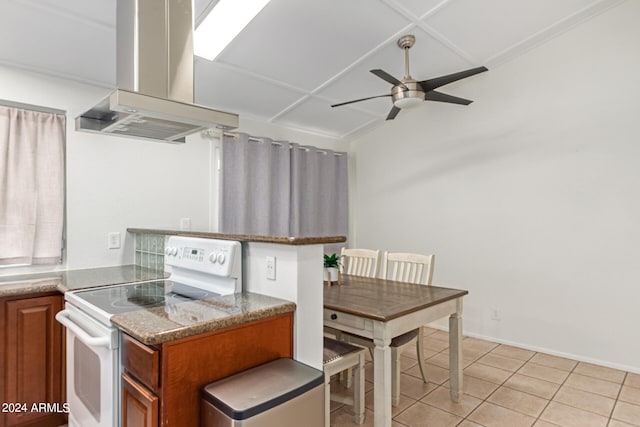 kitchen with island exhaust hood, white range with electric cooktop, light tile patterned floors, and ceiling fan