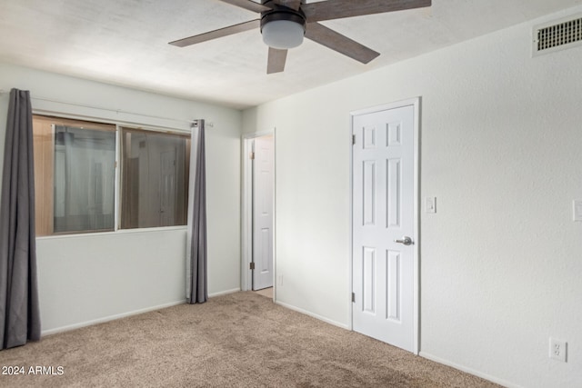 unfurnished bedroom featuring ceiling fan and carpet