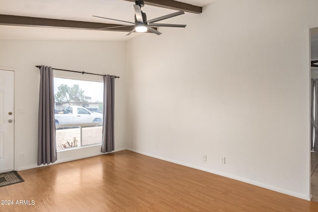 spare room featuring hardwood / wood-style floors, ceiling fan, and lofted ceiling with beams