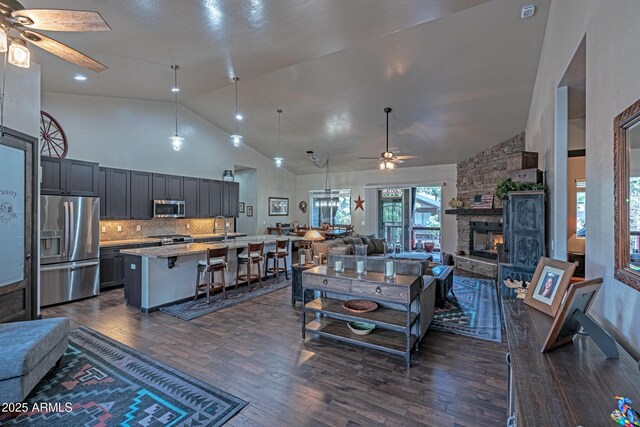 670 S Mountain Pines Ave, Show Low, AZ 85901 - living area featuring ceiling fan, dark wood finished floors, a stone fireplace, and high vaulted ceiling