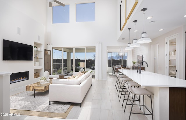 living room featuring a high ceiling, sink, and built in shelves