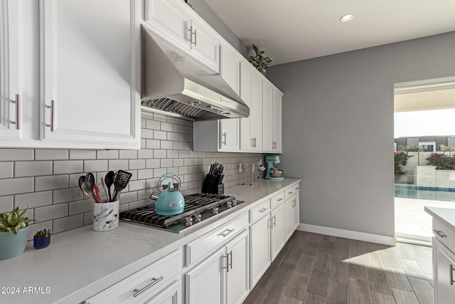 kitchen featuring light stone countertops, tasteful backsplash, stainless steel gas cooktop, dark hardwood / wood-style floors, and white cabinetry