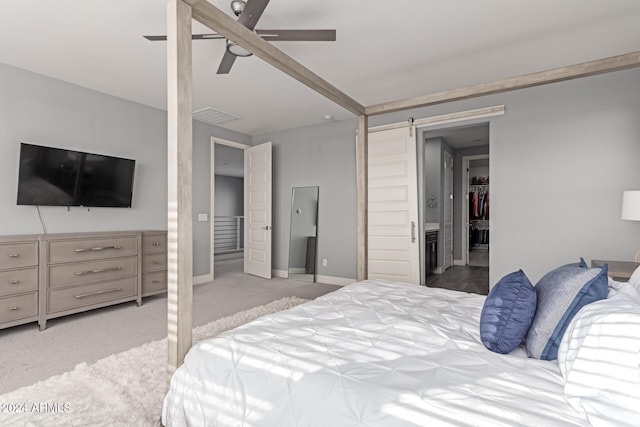 carpeted bedroom featuring a barn door and ceiling fan